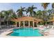 Beautiful community pool with covered lounge area, sun loungers, and lush landscaping at 3623 Square West Ln # 5, Sarasota, FL 34238