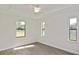 Bright bedroom featuring multiple windows, tray ceilings, and modern flooring at 3812 Wenona Dr, North Port, FL 34288