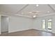 Spacious living room featuring wood flooring, tray ceilings, and modern ceiling fan at 3812 Wenona Dr, North Port, FL 34288