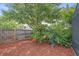 Lush backyard featuring a wooden fence, mature trees, and mulched ground cover at 4053 Lancaster Dr, Sarasota, FL 34241