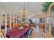 Elegant dining room with chandelier, tiled floors, mirrored walls, and a view into the living room, creating a stylish ambiance at 4053 Lancaster Dr, Sarasota, FL 34241