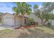 A well maintained home exterior with a two car garage, a lush tropical landscape, and a manicured lawn at 4053 Lancaster Dr, Sarasota, FL 34241