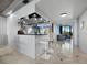 Stylish bar area with mirrored backdrop, seating for two, and views to the living room at 415 L Ambiance Dr # D306, Longboat Key, FL 34228