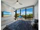 Bright bedroom featuring a large window with ocean views and a ceiling fan at 415 L Ambiance Dr # D306, Longboat Key, FL 34228