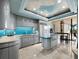 Modern kitchen with gray cabinets, blue backsplash, and marble floors, combining style and functionality at 415 L Ambiance Dr # D306, Longboat Key, FL 34228