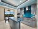 Contemporary kitchen features sleek cabinetry, blue accents, and eat-in area with access to balcony at 415 L Ambiance Dr # D306, Longboat Key, FL 34228