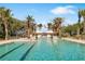 Large pool with marked lanes, palm trees, and an American flag flying in the background at 415 L Ambiance Dr # D306, Longboat Key, FL 34228