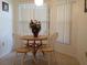 Bright breakfast nook with wooden table and chairs, surrounded by large windows with vertical blinds at 4315 45Th W Ave # 103, Bradenton, FL 34210