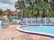 Community pool area features a clear swimming pool, lounge chairs and a hot tub surrounded by lush landscaping at 4315 45Th W Ave # 103, Bradenton, FL 34210