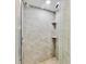 Modern shower with stone-look tile, corner shelves, and a glass door, for a luxurious bathing experience at 4315 45Th W Ave # 103, Bradenton, FL 34210