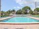 Large community swimming pool offers a refreshing escape, surrounded by lounge chairs and beautiful landscaping at 4315 45Th W Ave # 103, Bradenton, FL 34210