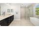 Bathroom featuring dual sinks, dark wood cabinets, a tub, and a shower at 437 Chantilly Trl, Bradenton, FL 34212