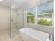 Bright bathroom featuring a soaking tub, shower, and a large window at 437 Chantilly Trl, Bradenton, FL 34212