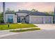 Charming single-story home with a three-car garage, manicured lawn, and stone-accented facade at 437 Chantilly Trl, Bradenton, FL 34212