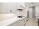 Modern kitchen features a gas cooktop, white cabinetry, quartz countertops, and stainless steel appliances at 437 Chantilly Trl, Bradenton, FL 34212