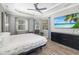 Spacious main bedroom with a television, wood-look floors, and a ceiling fan at 437 Chantilly Trl, Bradenton, FL 34212