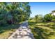 Scenic view along the walkway with green grass and shade trees at 437 Chantilly Trl, Bradenton, FL 34212