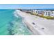 Aerial view of a beachfront community with white buildings, turquoise water, and sandy shores at 4380 Exeter Dr # 304, Longboat Key, FL 34228