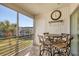 Cozy screened balcony is perfect for dining with table, four chairs, and relaxing views at 4380 Exeter Dr # 304, Longboat Key, FL 34228