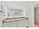 Bathroom featuring double sinks, granite countertops, and a frameless lighted mirror at 4380 Exeter Dr # 304, Longboat Key, FL 34228