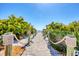 Picturesque beach path framed by lush greenery and rope railings, leading to the ocean at 4380 Exeter Dr # 304, Longboat Key, FL 34228