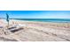 Calm beach view featuring lounge chairs and an umbrella, perfect for relaxation at 4380 Exeter Dr # 304, Longboat Key, FL 34228