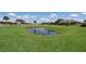 Expansive backyard with a serene pond and white picket fence, offering a peaceful retreat at 4610 13Th W St, Palmetto, FL 34221