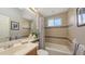 Bathroom with beige tile, a framed mirror, and a tub/shower with shower curtain at 4832 Carrington Cir, Sarasota, FL 34243