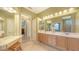 Large bathroom features a vanity with double sinks, wood cabinets and a seamless glass shower at 4832 Carrington Cir, Sarasota, FL 34243