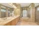 Bright bathroom boasts a double vanity, soaking tub, glass enclosed shower and neutral color palette at 4832 Carrington Cir, Sarasota, FL 34243