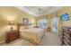 Light-filled bedroom with a ceiling fan, large windows, and tasteful decor at 4832 Carrington Cir, Sarasota, FL 34243