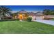 Stunning home exterior with a lush green lawn, mature palm trees, and a two-car garage at 4832 Carrington Cir, Sarasota, FL 34243