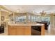 This kitchen features a sink, dishwasher, wood cabinets, and a view into the living room at 4832 Carrington Cir, Sarasota, FL 34243