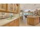 Kitchen with wood cabinets and countertop overlooking a living room with large windows at 4832 Carrington Cir, Sarasota, FL 34243