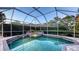 Screened-in pool with attached spa with mosaic tiling and lush landscaping at 4832 Carrington Cir, Sarasota, FL 34243