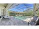 Relaxing screened in pool area with tiled pool, patio seating, and manicured landscaping at 4832 Carrington Cir, Sarasota, FL 34243