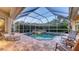 Relaxing screened in pool area with tiled pool, patio seating, and manicured landscaping at 4832 Carrington Cir, Sarasota, FL 34243