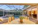 Picturesque screened-in pool area with an outdoor dining setup and lush landscaping, creating a serene retreat at 4832 Carrington Cir, Sarasota, FL 34243