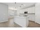Bright kitchen area featuring white cabinets, an island with sink, and modern pendant lighting at 4951 Oyster Pearl St, Lakewood Ranch, FL 34211