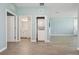 Open-concept living room with in unit laundry closet, view to bathroom and white colored walls at 4951 Oyster Pearl St, Lakewood Ranch, FL 34211