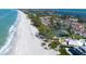 A stunning aerial view featuring beachfront condos and tennis courts along a beautiful, white sandy beach at 5055 Gulf Of Mexico Dr # 414, Longboat Key, FL 34228