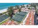 Beautiful aerial view of community tennis courts near the beach with updated buildings and lush landscaping at 5055 Gulf Of Mexico Dr # 414, Longboat Key, FL 34228