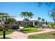 Clubhouse with outdoor seating and tropical landscaping featuring palm trees and lush green grass at 5055 Gulf Of Mexico Dr # 414, Longboat Key, FL 34228