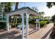 Charming gazebo featuring a table and chairs, ideal for outdoor gatherings and relaxing in a serene setting at 5055 Gulf Of Mexico Dr # 414, Longboat Key, FL 34228