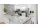 Bright kitchen featuring granite counters, stainless steel appliances, and a stylish backsplash at 5055 Gulf Of Mexico Dr # 414, Longboat Key, FL 34228