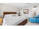 Sunny main bedroom featuring a king bed, wood headboard, and an accent chair at 5055 Gulf Of Mexico Dr # 414, Longboat Key, FL 34228