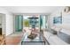 Living room with glass doors leading to a patio area and landscaped garden at 5055 Gulf Of Mexico Dr # 414, Longboat Key, FL 34228