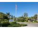 Community entrance featuring Club Longboat sign, an American flag, mature trees, and immaculate landscaping at 5055 Gulf Of Mexico Dr # 414, Longboat Key, FL 34228