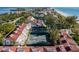 Scenic aerial view of community tennis courts surrounded by lush landscaping, beach, and beautiful architecture at 5055 Gulf Of Mexico Dr # 414, Longboat Key, FL 34228