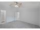 Bedroom features neutral carpet, ceiling fan, and access to bathroom and hallway at 5382 Royal Palm Ave # 5382, Sarasota, FL 34234